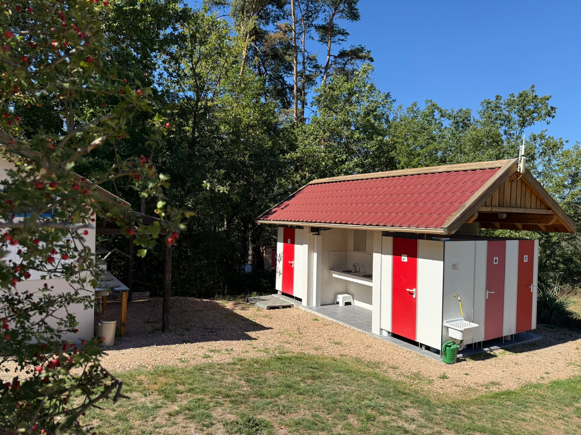 Bâtiment sanitaire dans la verdure du Camping Le Pré Doux